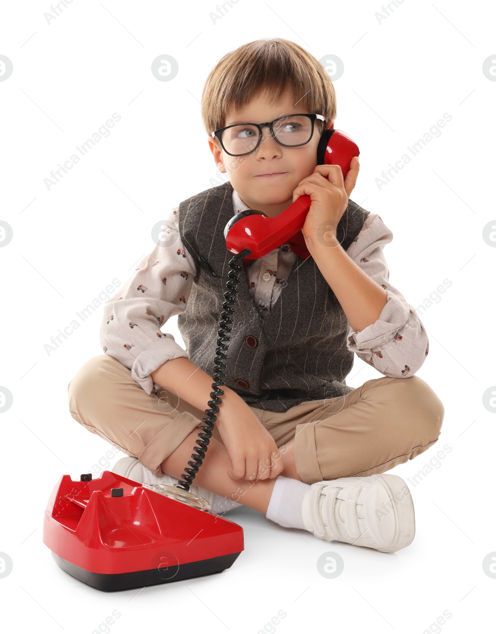 Photo of Cute little boy with old telephone on white background