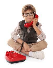 Photo of Cute little boy with old telephone on white background