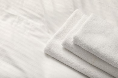 Photo of Stack of towels on clean linens indoors, closeup. Space for text