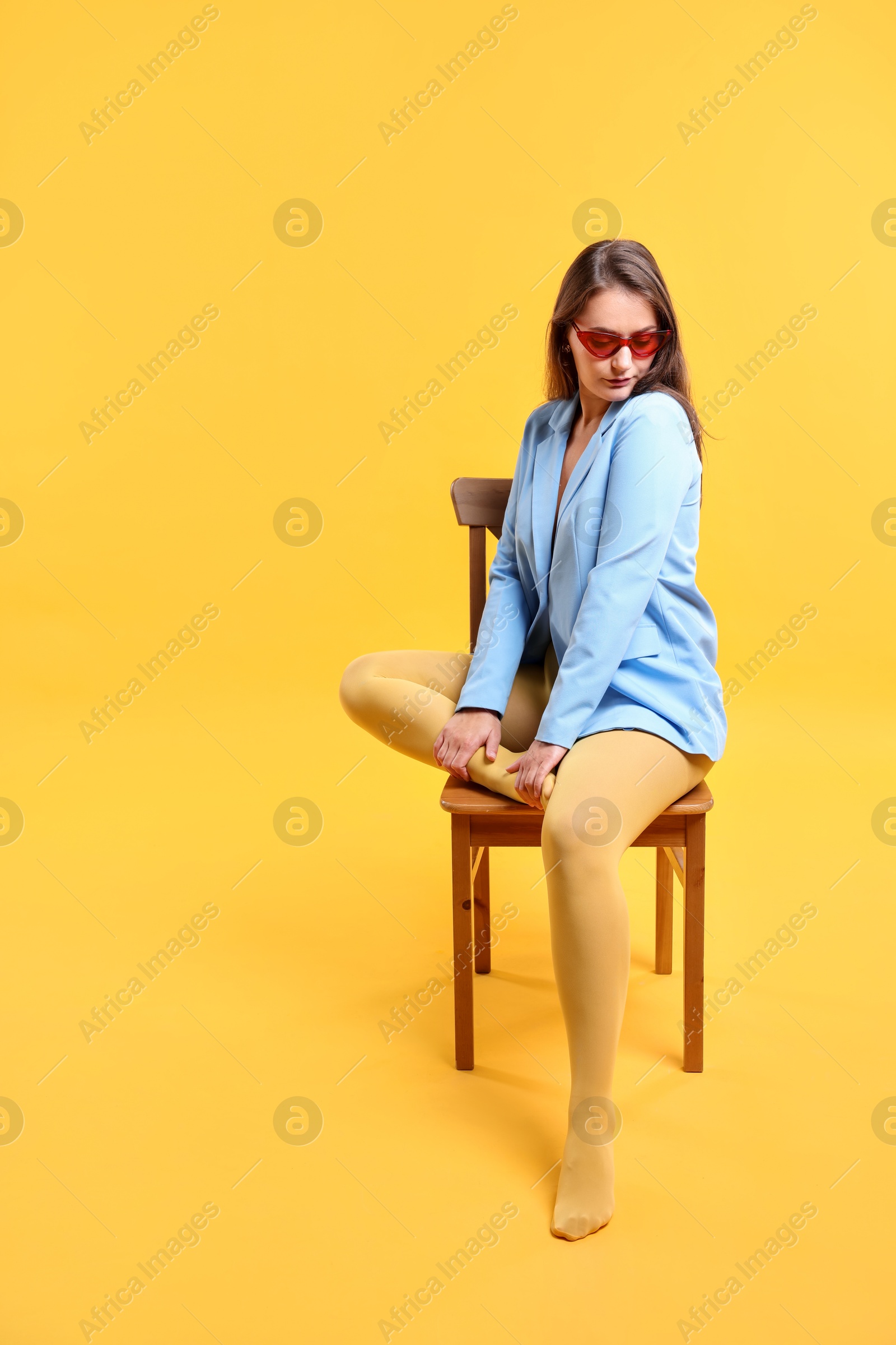 Photo of Pretty young woman posing on yellow background