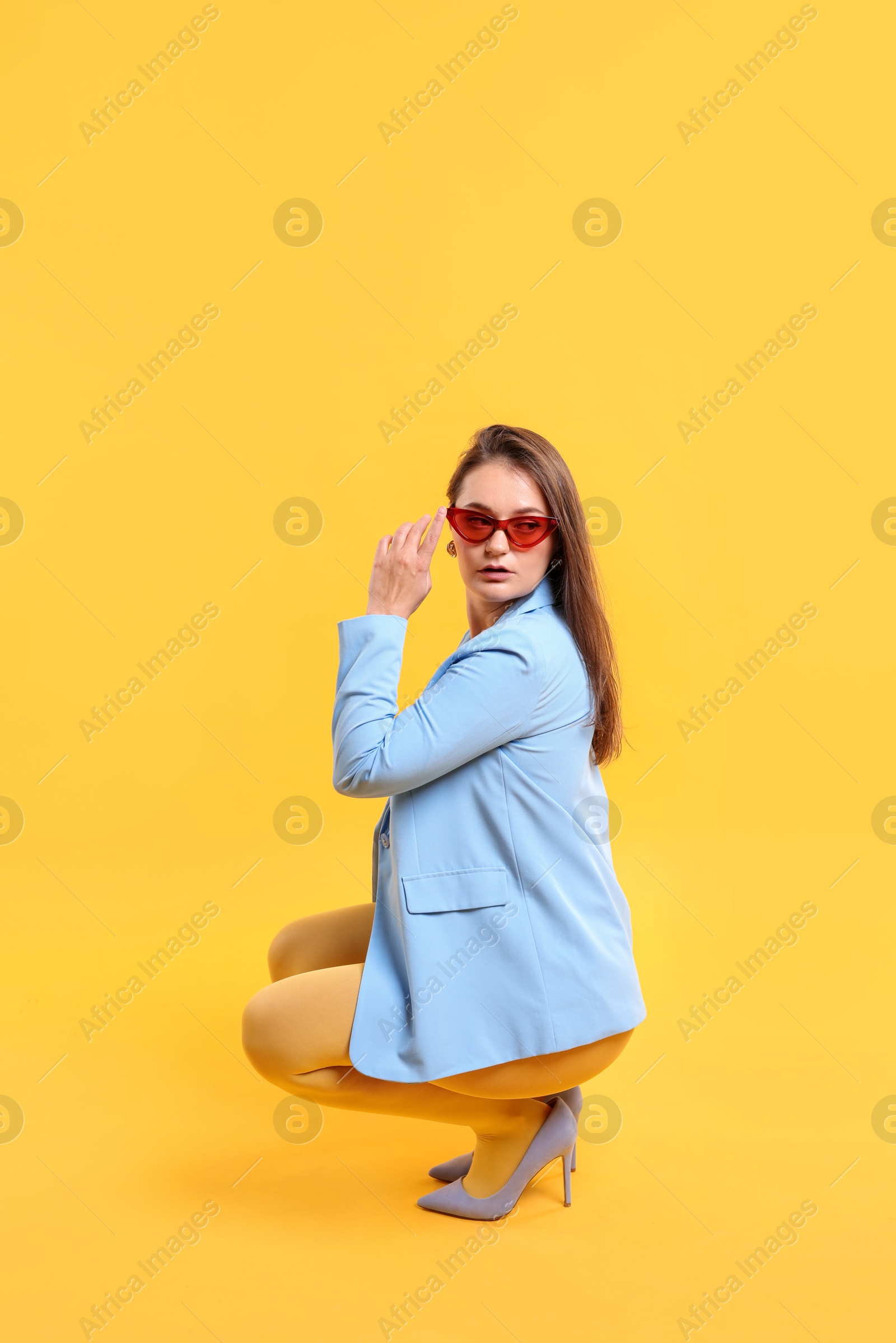 Photo of Pretty young woman posing on yellow background