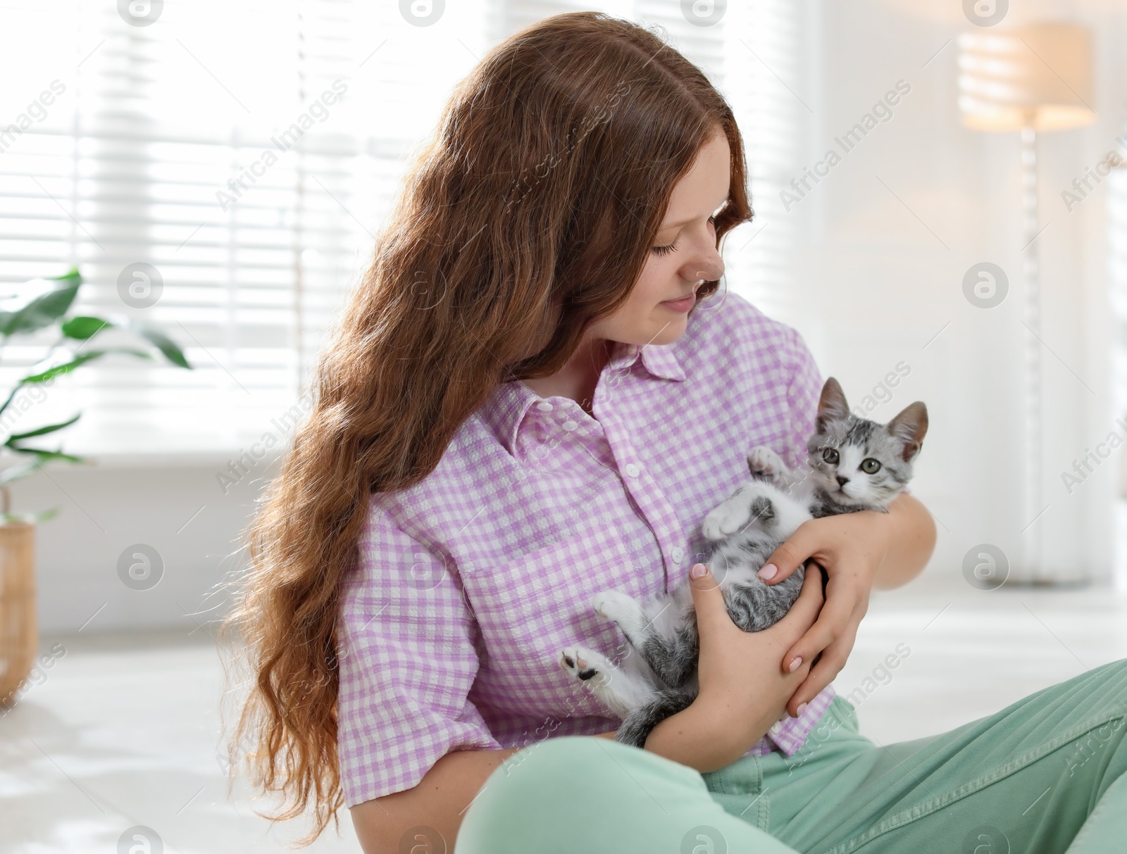 Photo of Beautiful teenage girl with cute cat at home