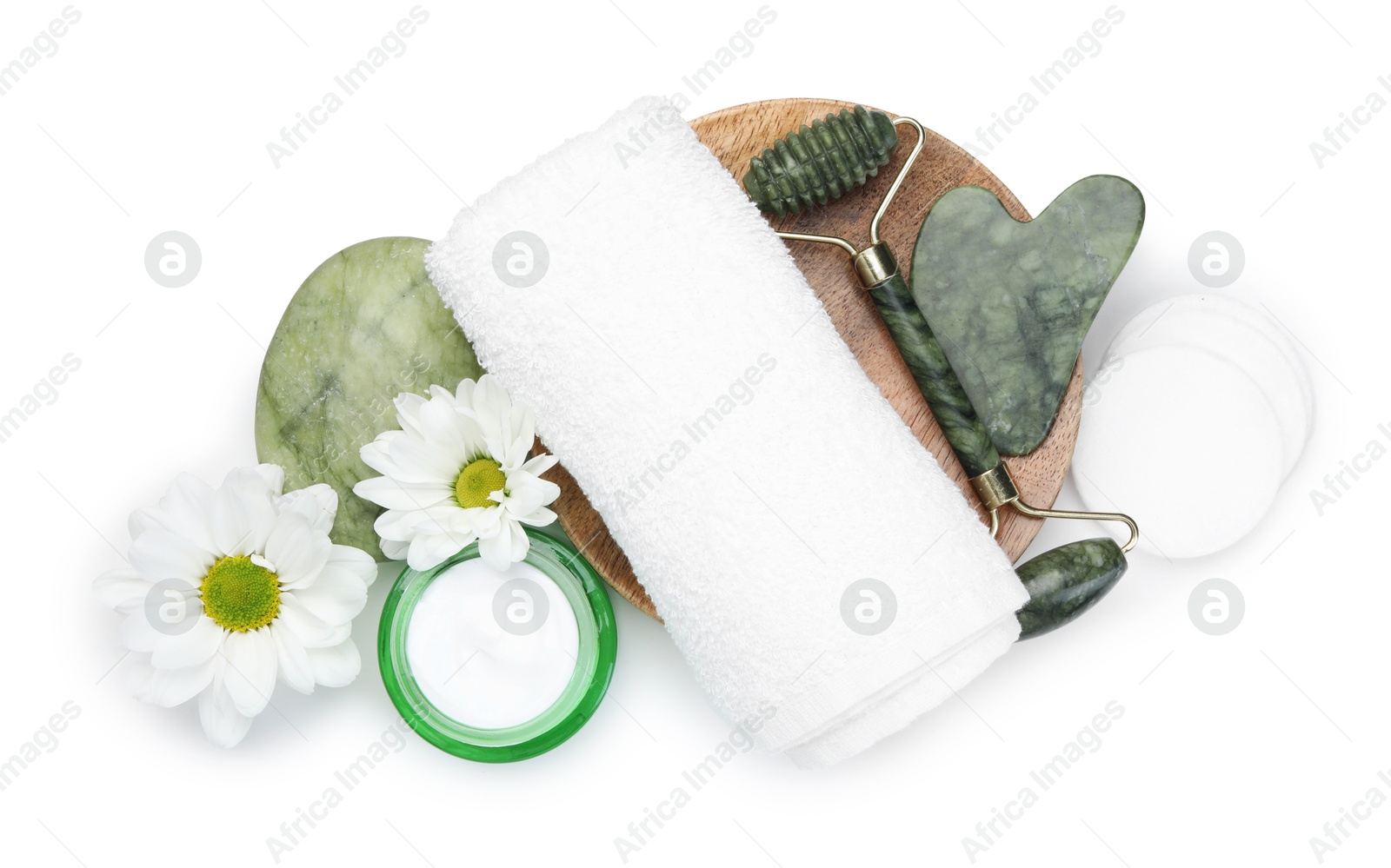 Photo of Face roller, cosmetic products, gua sha and flowers isolated on white