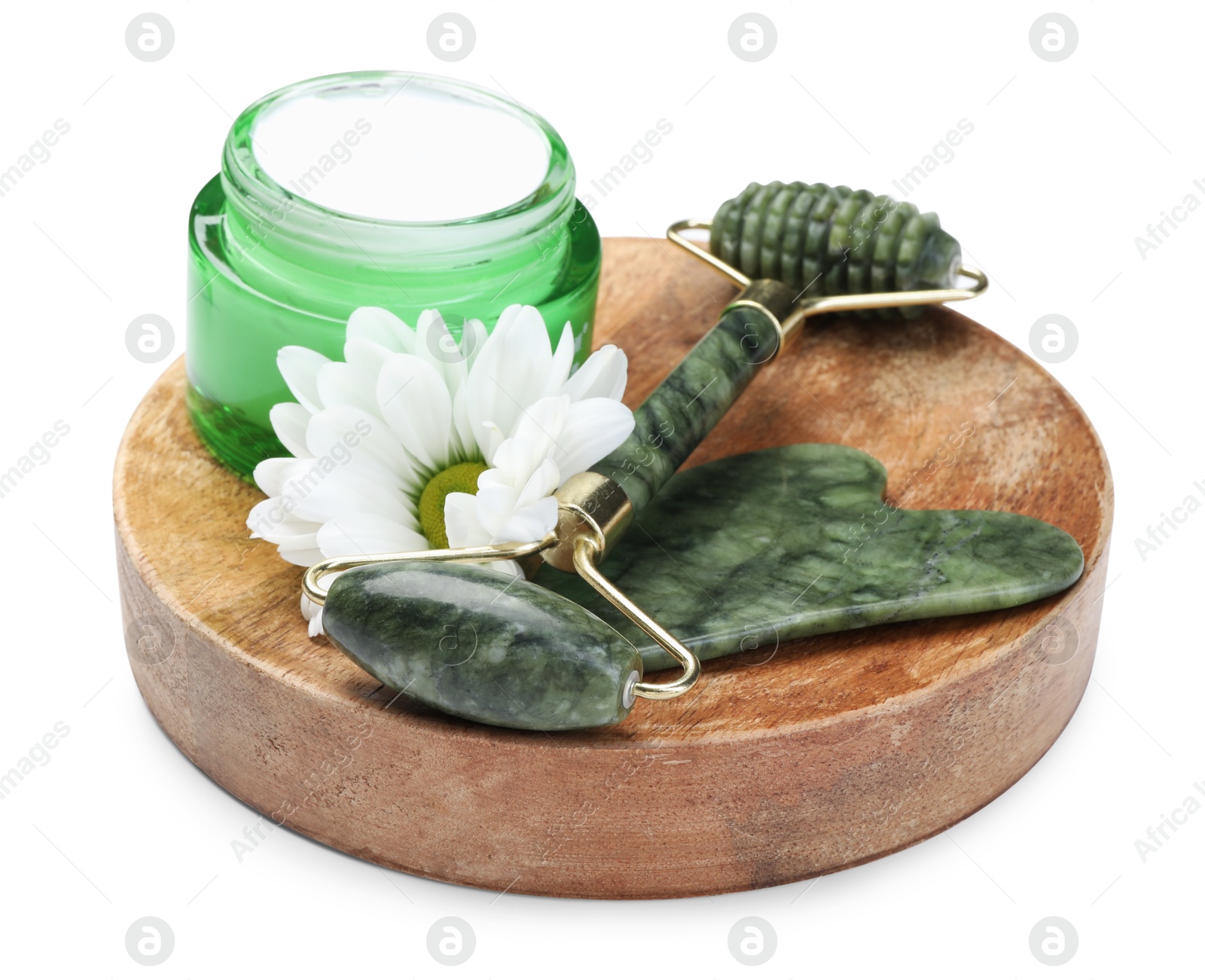 Photo of Face roller, cream, gua sha and flower isolated on white