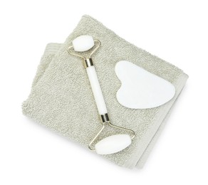 Photo of Face roller, gua sha tool and towel isolated on white, top view