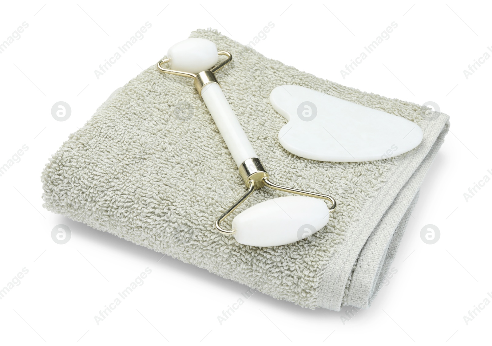 Photo of Face roller, gua sha tool and towel isolated on white