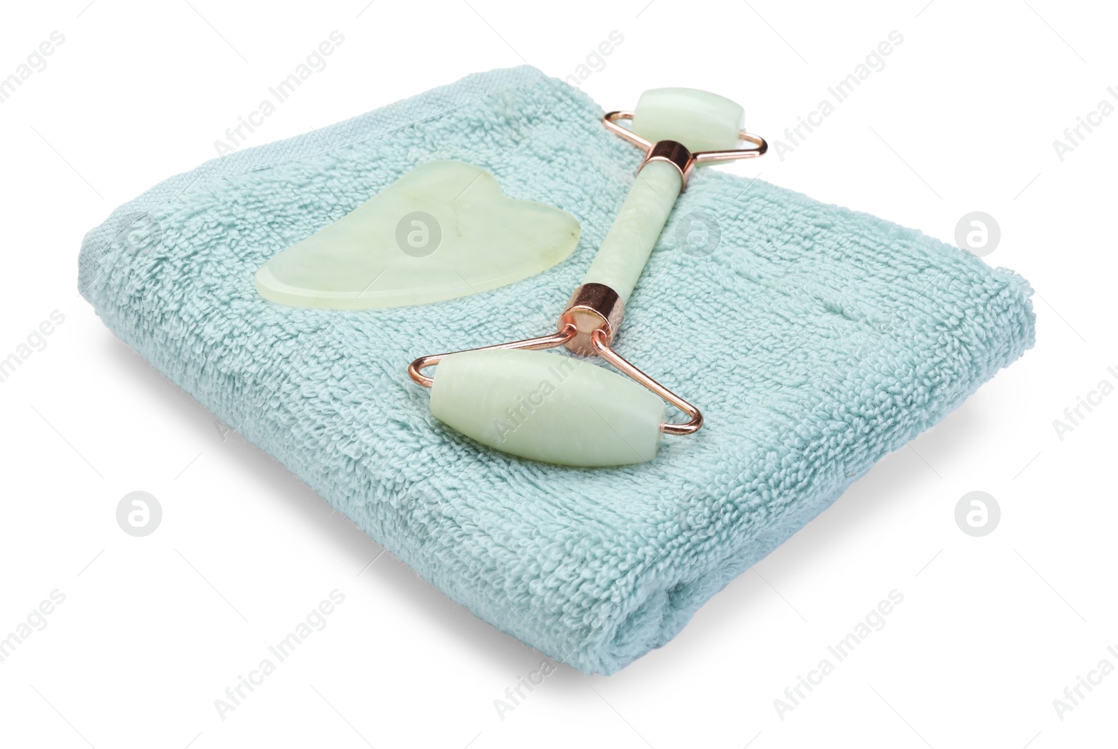 Photo of Face roller, gua sha tool and towel isolated on white