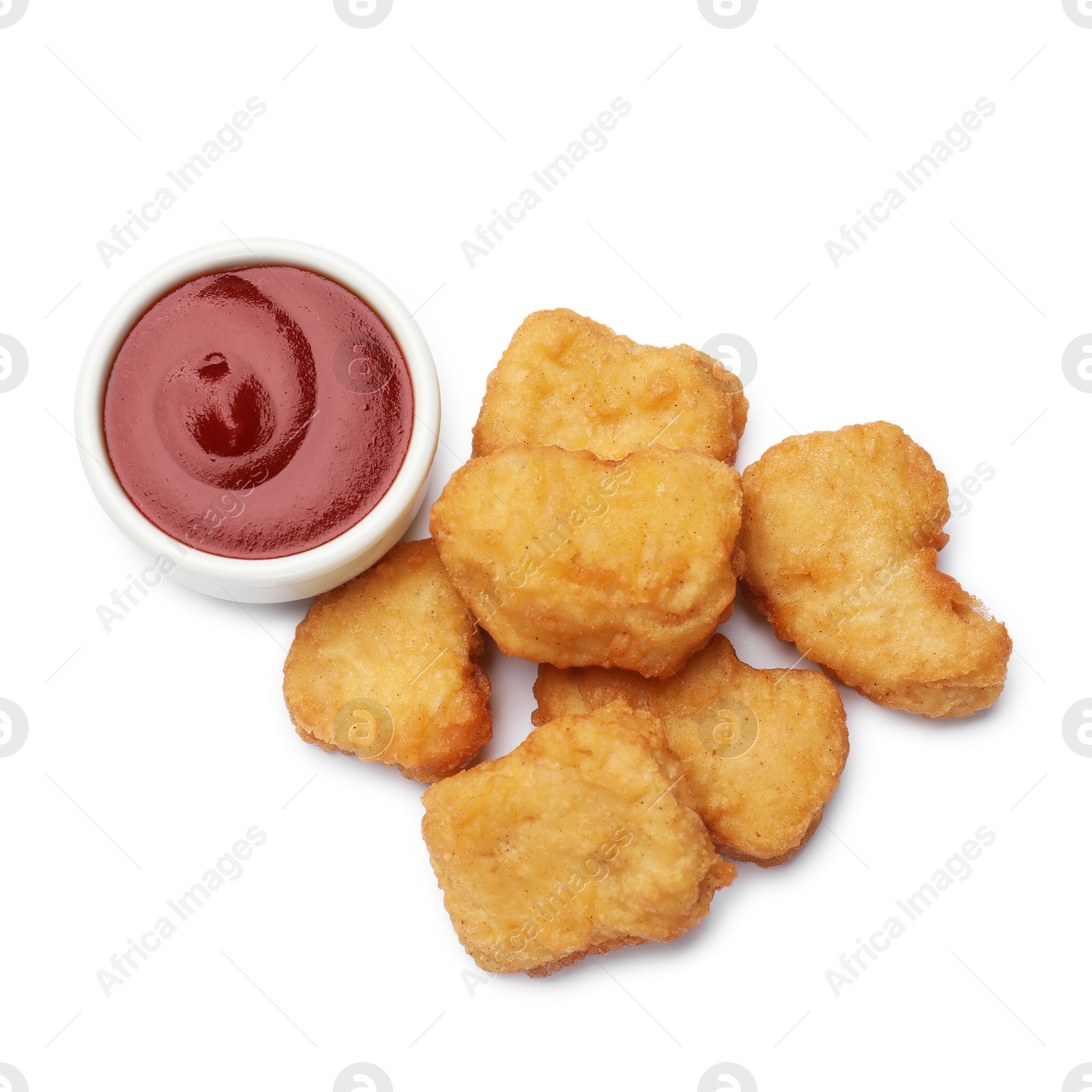 Photo of Delicious chicken nuggets with ketchup isolated on white, top view