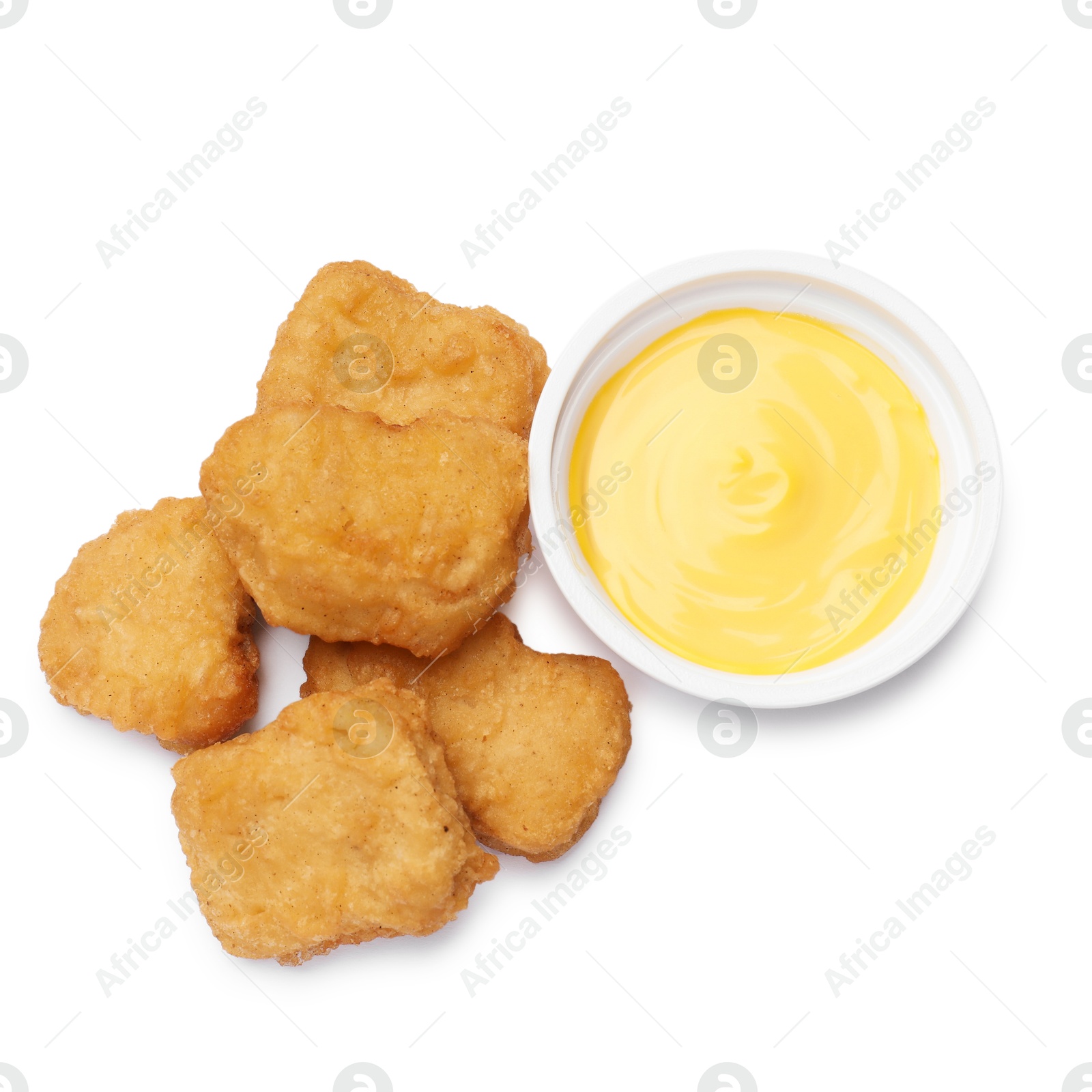 Photo of Delicious chicken nuggets with sauce isolated on white, top view