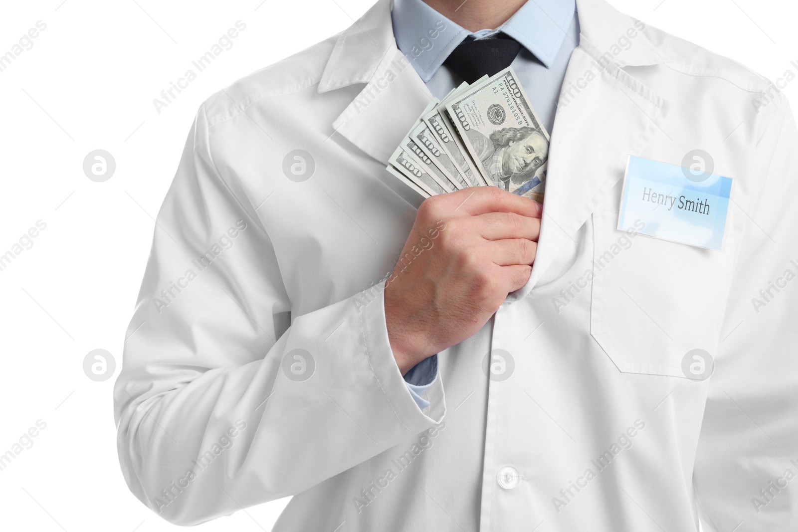 Photo of Corruption concept. Doctor putting dollar banknotes into his coat on white background, closeup