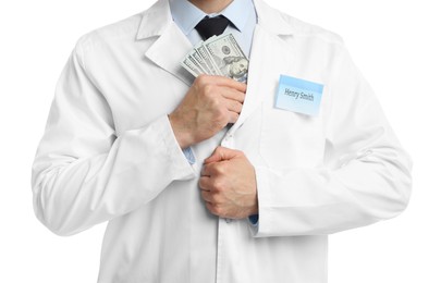 Photo of Corruption concept. Doctor putting dollar banknotes into his coat on white background, closeup