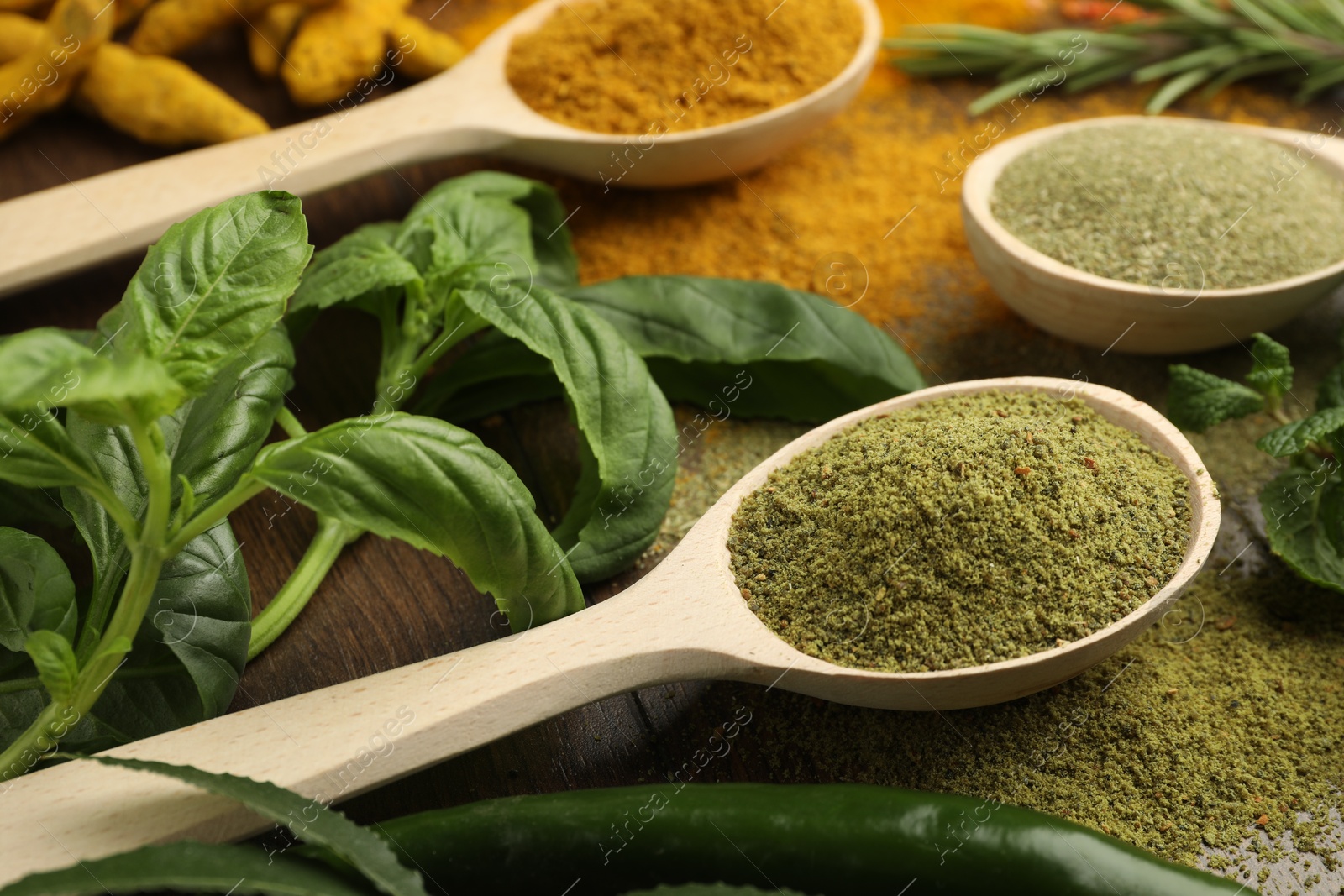 Photo of Different aromatic spices and herbs on wooden table, closeup