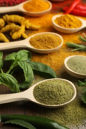 Photo of Different aromatic spices and herbs on wooden table, closeup