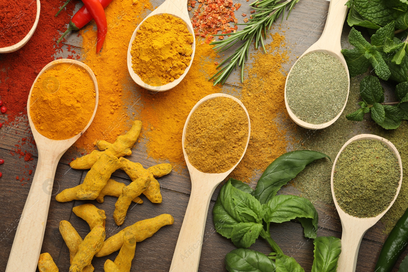 Photo of Different aromatic spices and herbs on wooden table, flat lay