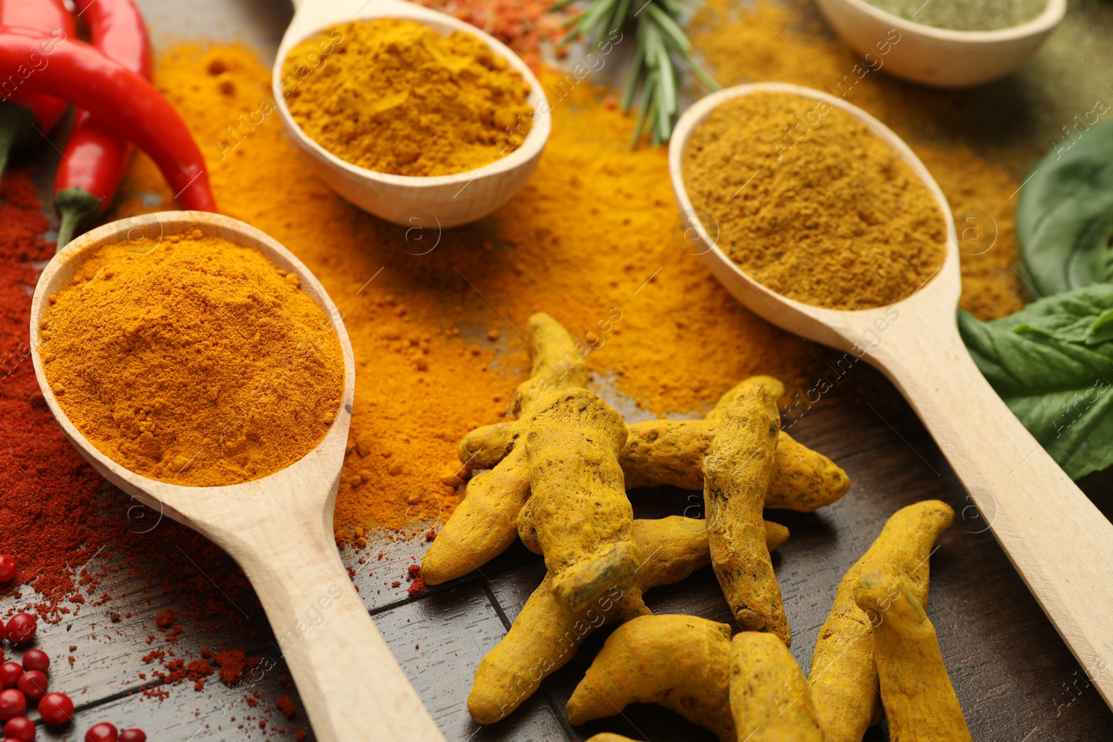 Photo of Different aromatic spices on wooden table, closeup