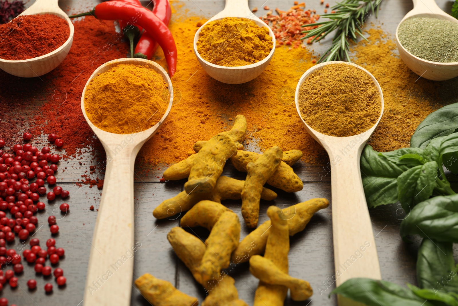 Photo of Different aromatic spices and herbs on wooden table, closeup