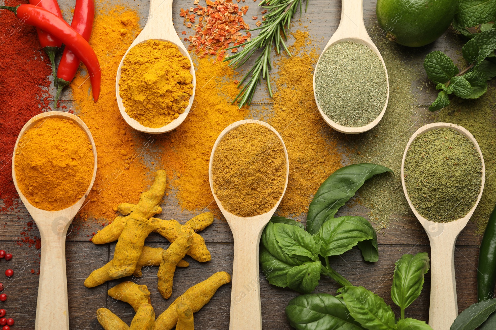 Photo of Different aromatic spices and herbs on wooden table, flat lay