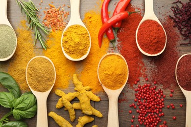 Photo of Different aromatic spices and herbs on wooden table, flat lay