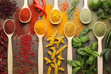 Photo of Different aromatic spices and herbs on wooden table, flat lay