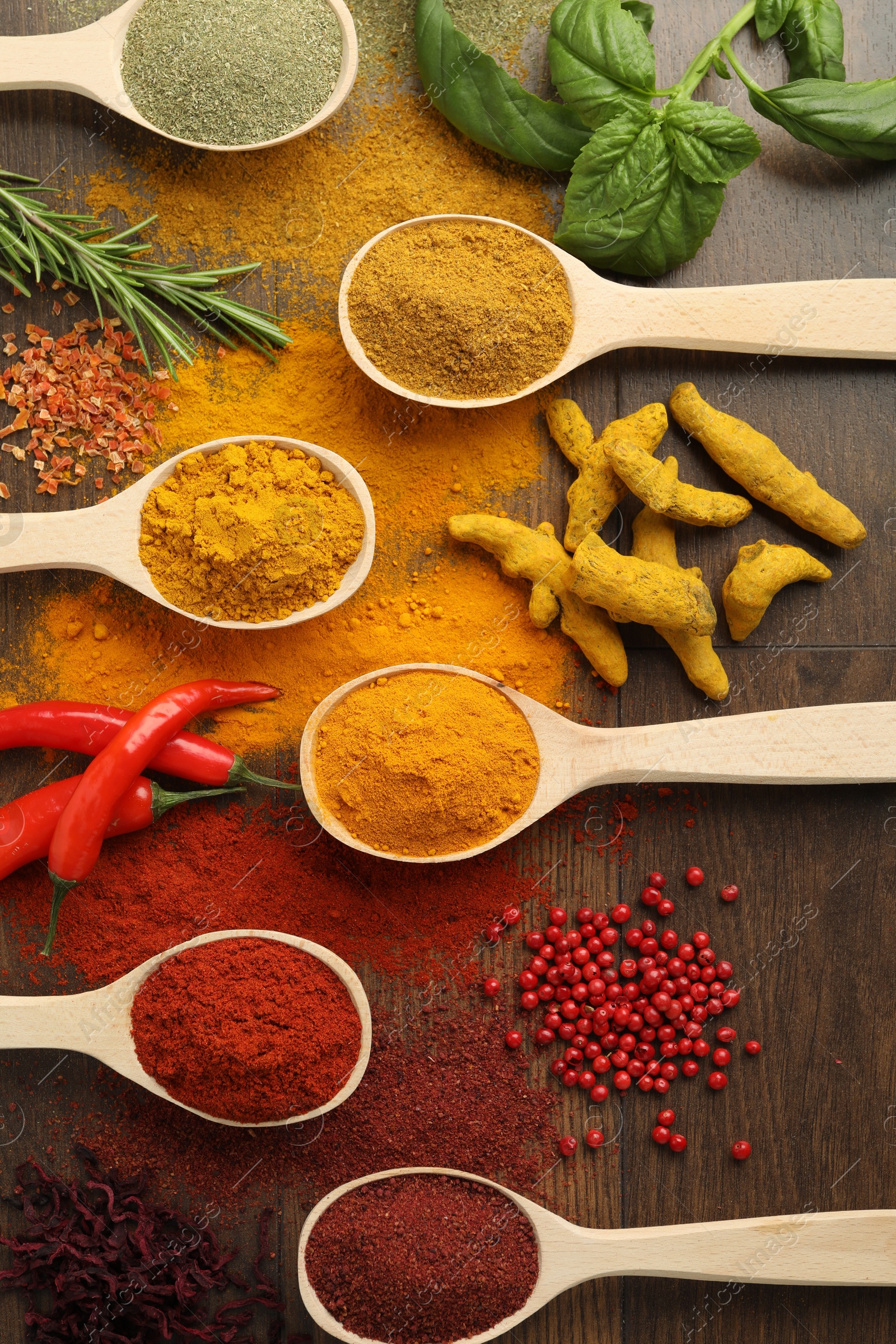 Photo of Different aromatic spices and herbs on wooden table, flat lay