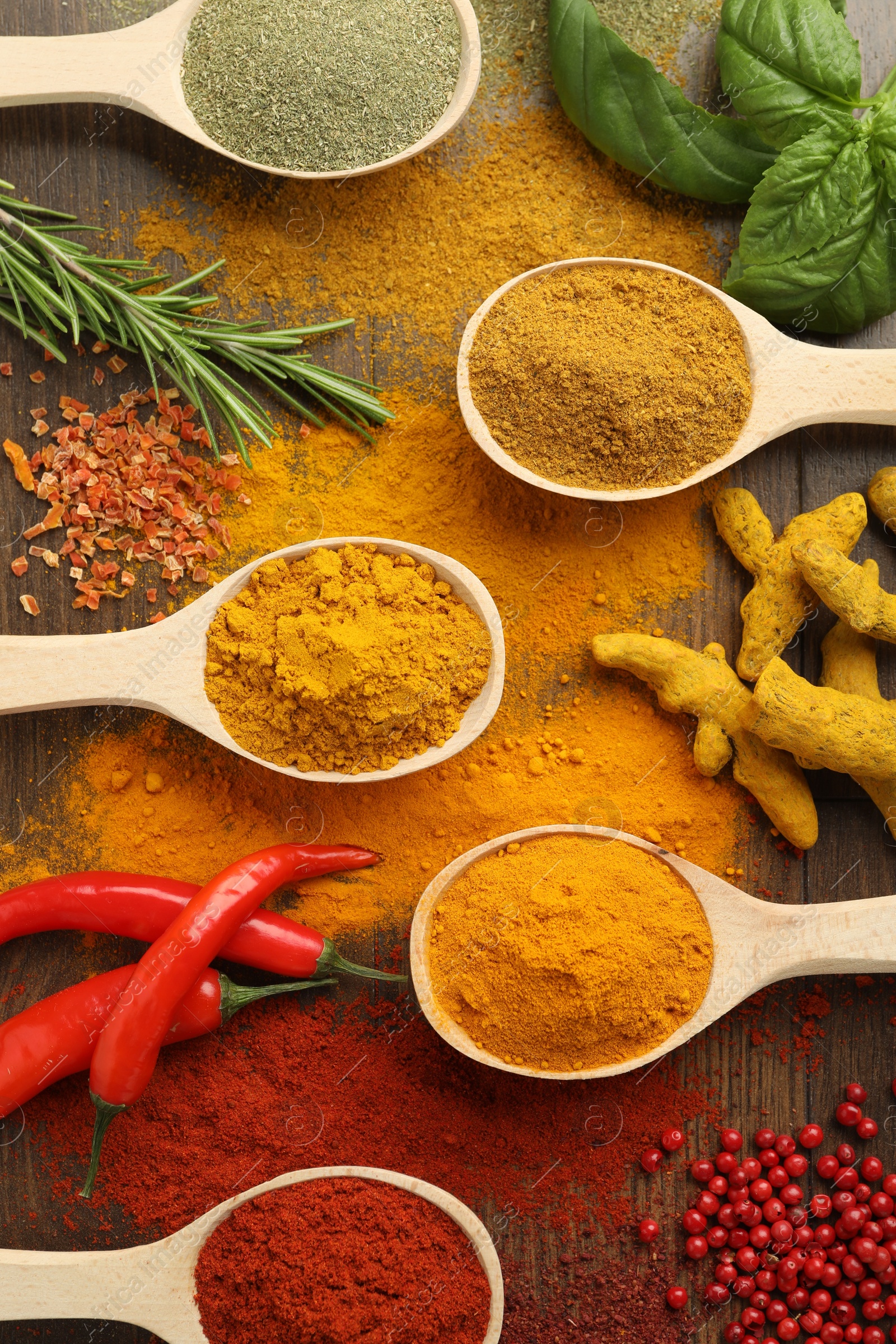 Photo of Different aromatic spices and herbs on wooden table, flat lay