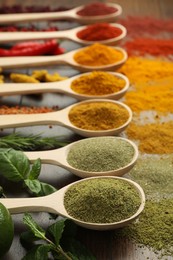 Photo of Different aromatic spices and herbs on wooden table, closeup