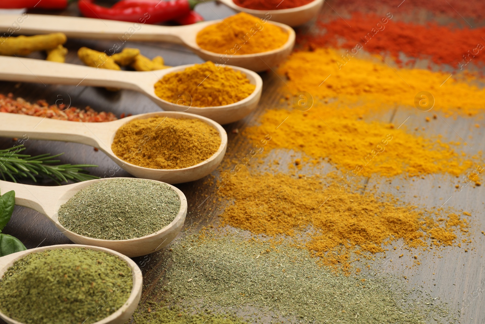 Photo of Different aromatic spices and herbs on wooden table, closeup