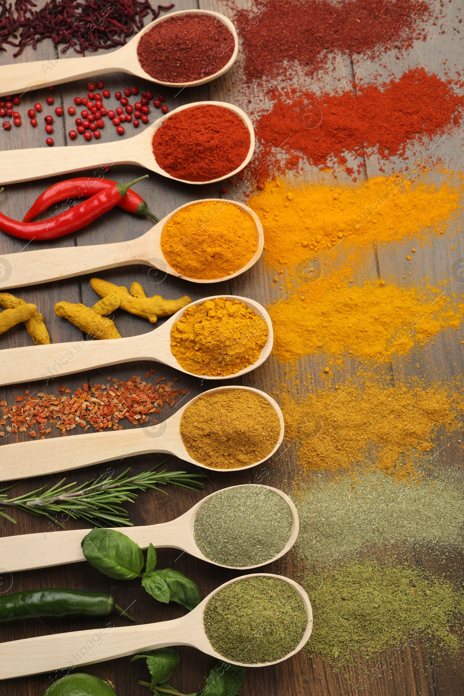 Photo of Different aromatic spices and herbs on wooden table, flat lay