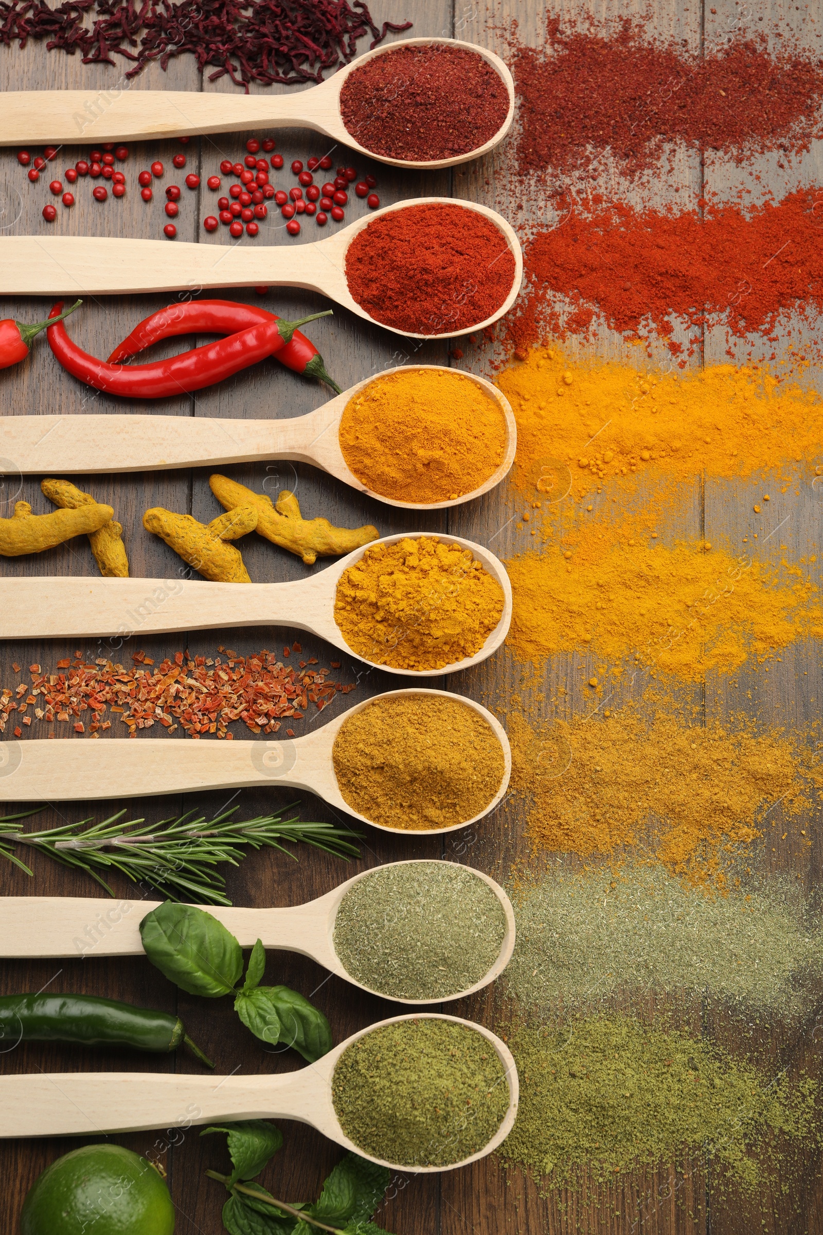 Photo of Different aromatic spices and herbs on wooden table, flat lay