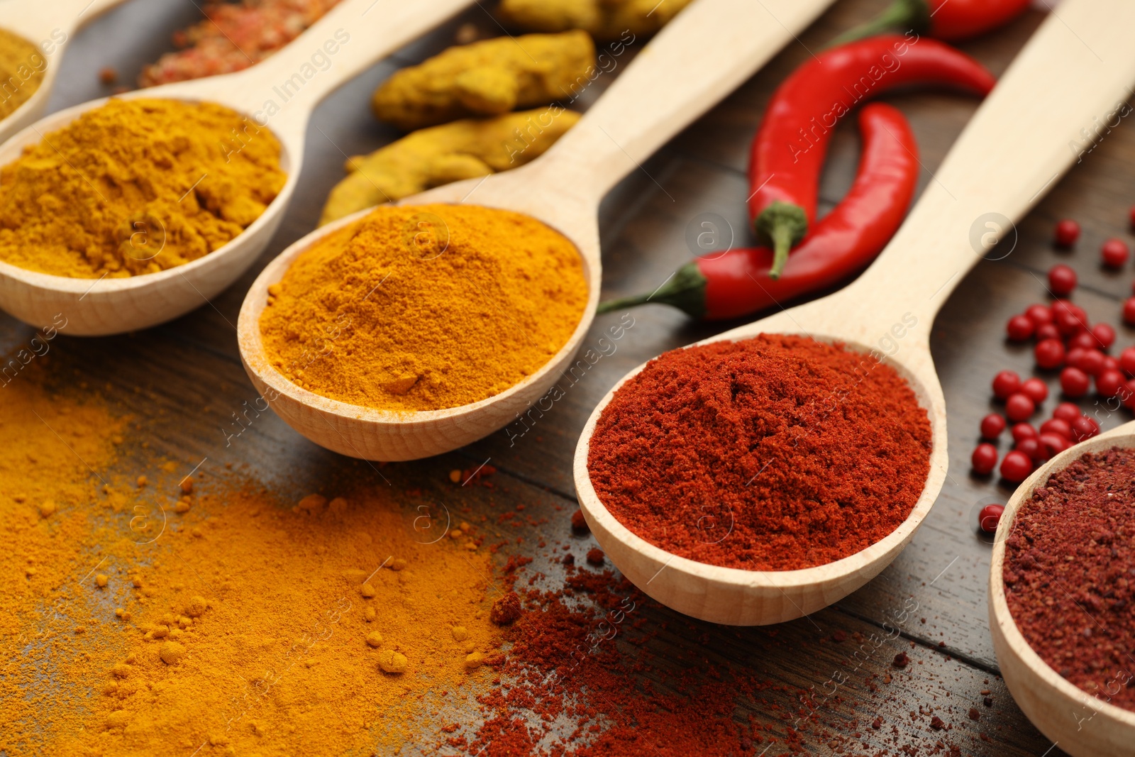 Photo of Different aromatic spices on wooden table, closeup