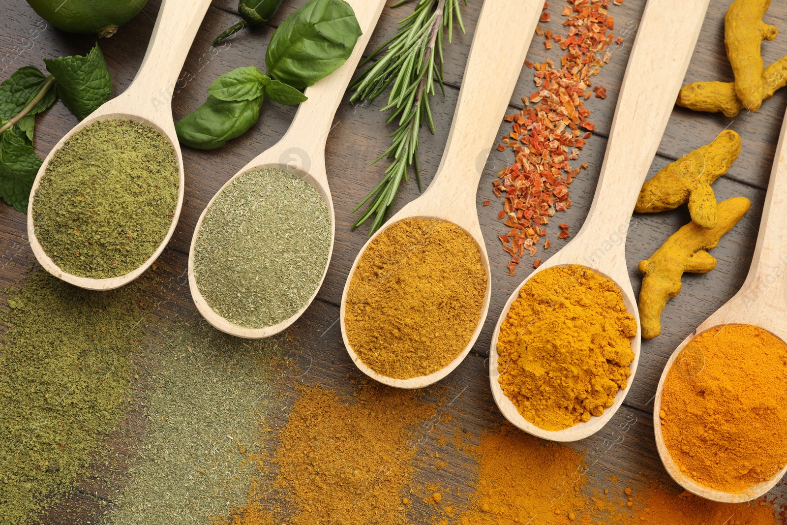 Photo of Different aromatic spices and herbs on wooden table, flat lay