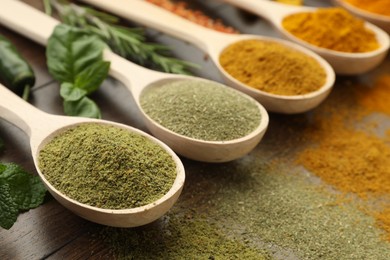 Photo of Different aromatic spices and herbs on wooden table, closeup