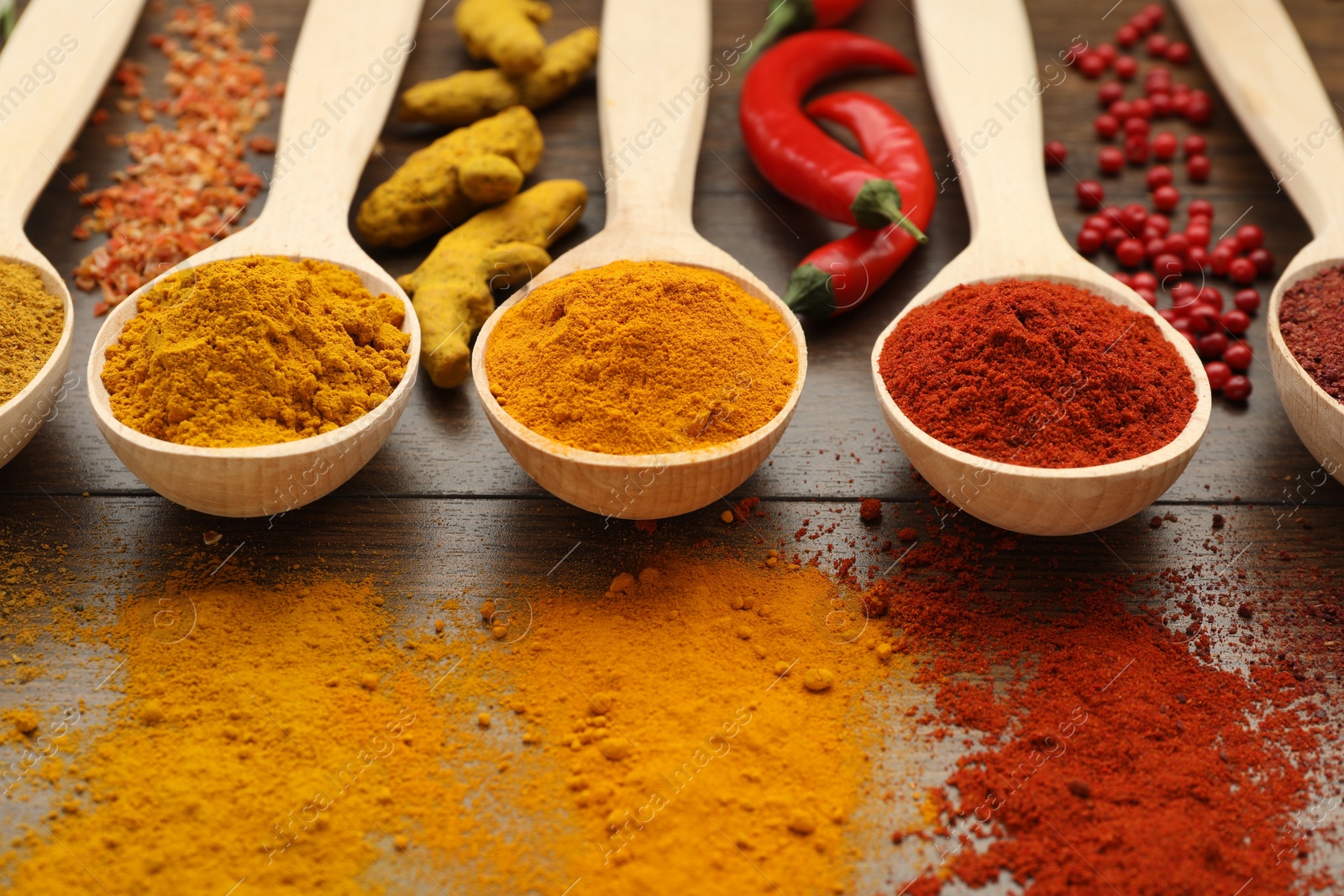 Photo of Different aromatic spices on wooden table, closeup