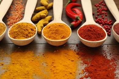 Different aromatic spices on wooden table, closeup