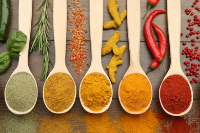 Photo of Different aromatic spices and herbs on wooden table, flat lay