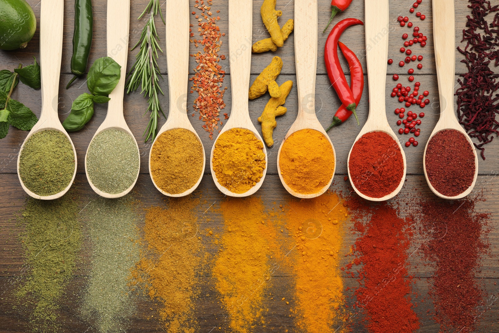 Photo of Different aromatic spices and herbs on wooden table, flat lay