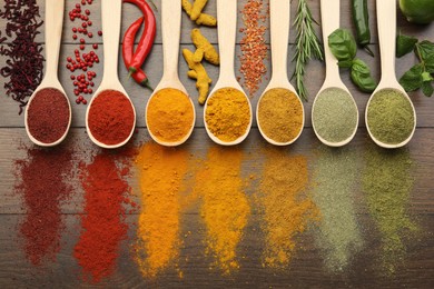 Photo of Different aromatic spices and herbs on wooden table, flat lay