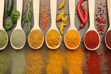 Photo of Different aromatic spices and herbs on wooden table, flat lay