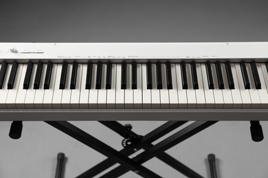 Photo of Synthesizer on grey background, closeup. Electronic musical instrument