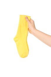 Photo of Woman holding pair of yellow socks on white background, closeup