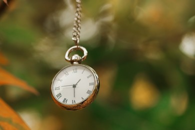 Photo of Autumn time. Chain watch on blurred background, closeup with space for text