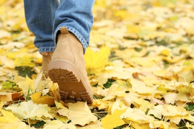 Photo of Man walking on grass with fallen leaves, closeup. Space for text