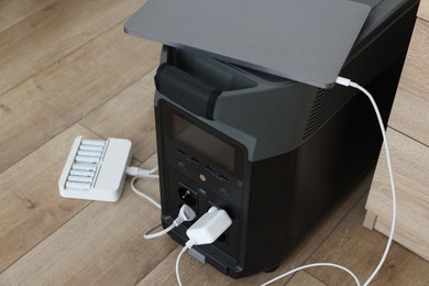 Photo of Modern portable power station, charging attached devices indoors