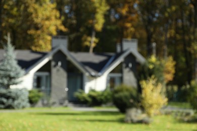 Photo of Blurred view of hotel buildings and different plants in autumnal park