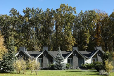 Photo of Hotel buildings and different plants in autumnal park