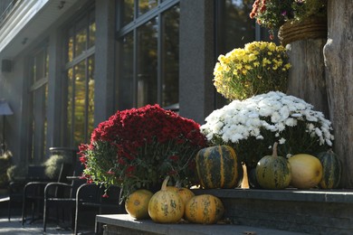 Entrance of modern cafe decorated with flowers and pumpkins