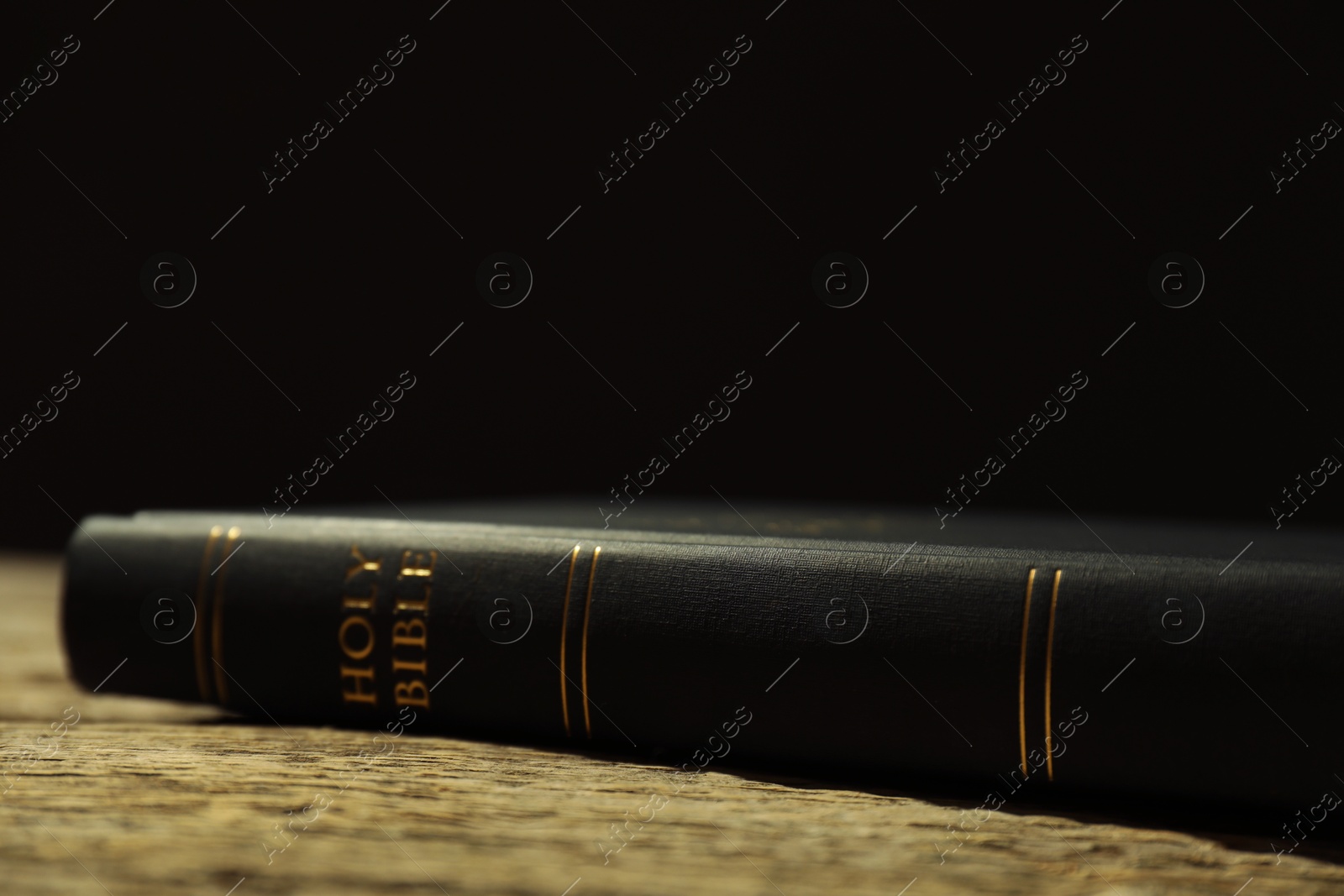 Photo of Hardcover Holy Bible on wooden table, closeup. Space for text