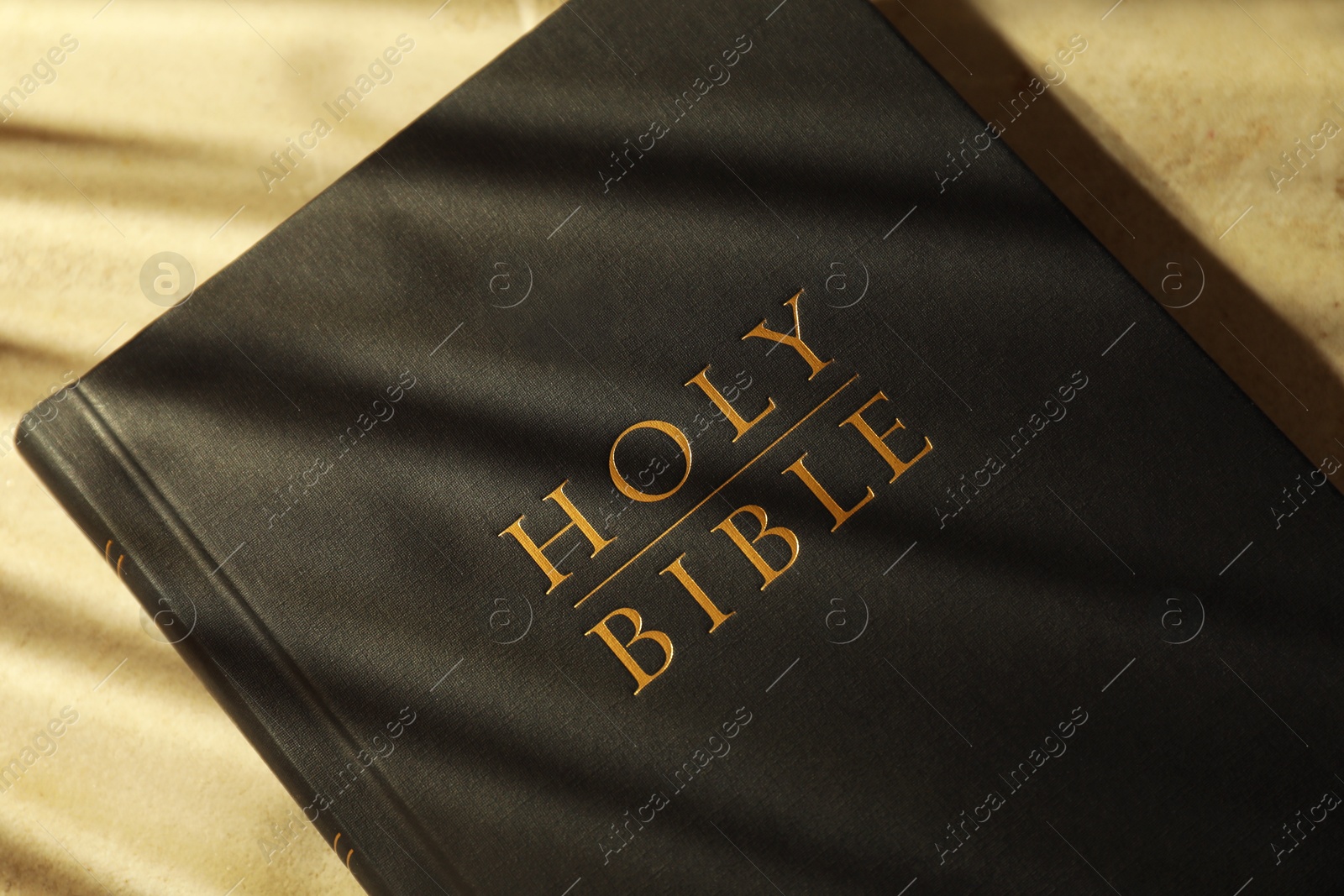 Photo of Hardcover Holy Bible on beige table, top view