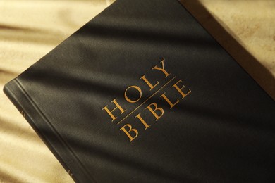 Photo of Hardcover Holy Bible on beige table, top view