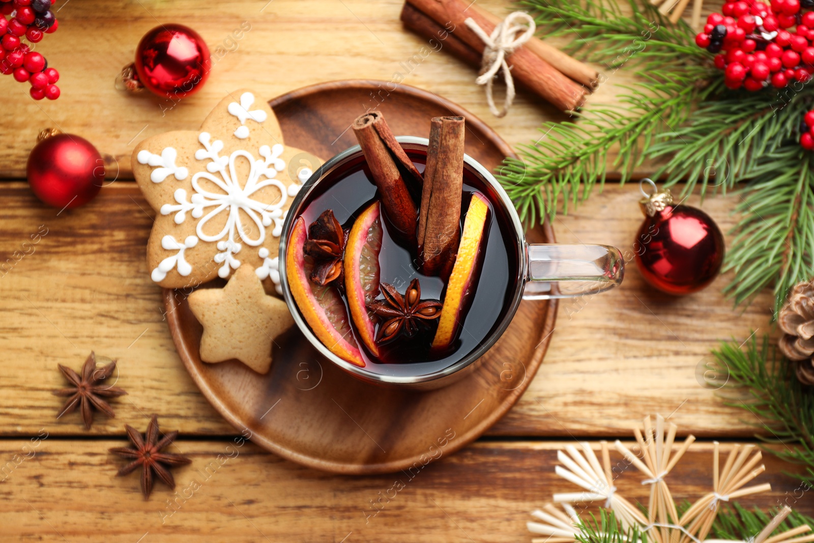 Photo of Tasty mulled wine with spices, cookies and Christmas decor on wooden table, flat lay